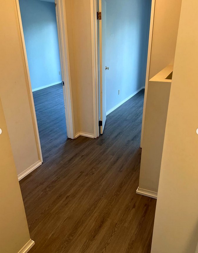 Walnut-tone wood-look flooring in a hallway
